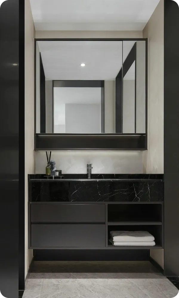Wide black-framed mirror above a black marble vanity in a dark modern bathroom