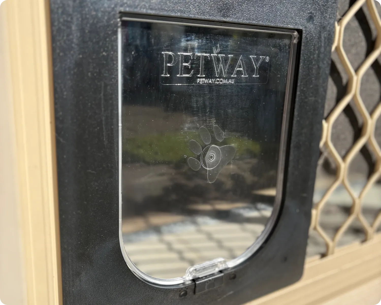 Petway pet door flap fitted into a cream diamond grille safety door